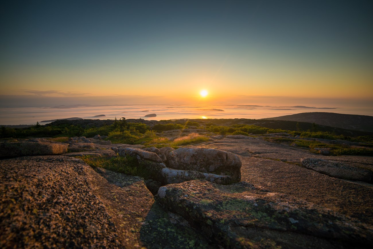 Sunrise and fog from a rocky summit