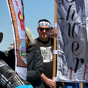 Man wearing bandana holds banner in crowd