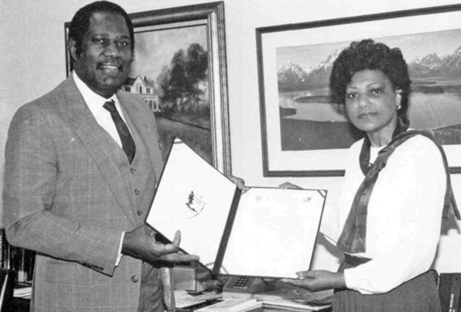 Lillie Walker and Robert Stanton pose holding an award between them.