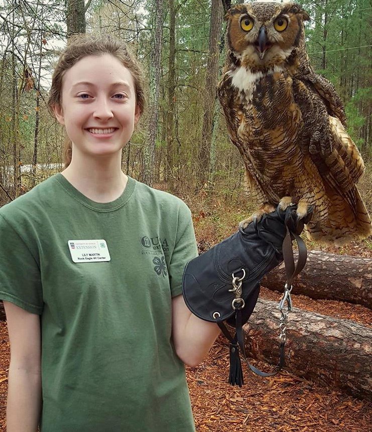 Lily Martin Woman smiling with an owl perched on her hand.