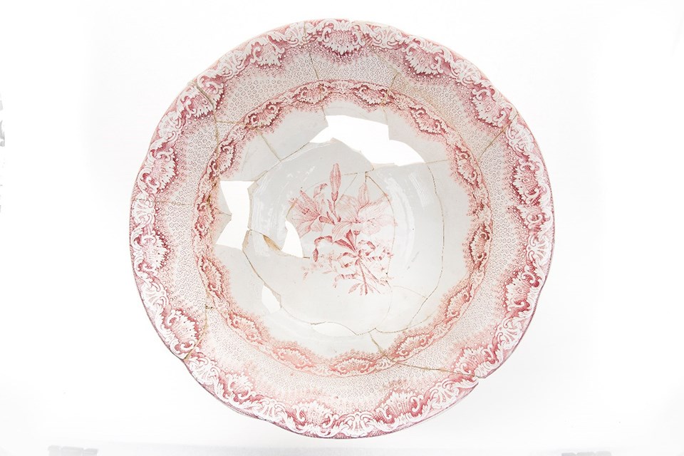 Top view of a large washbasin. It is white with a pink transfer print design that has flowers and decorative designs.