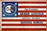 A campaign flag in the colors of the American flag, with the words “For President: Abram Lincoln, for Vice President Hannibal Hamlin.” Lincoln’s face appears in the blue square surrounded by white stars.