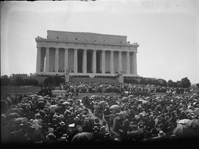 Wide shot of the Lincoln Memorial on the day of dedication with a large crowd in front