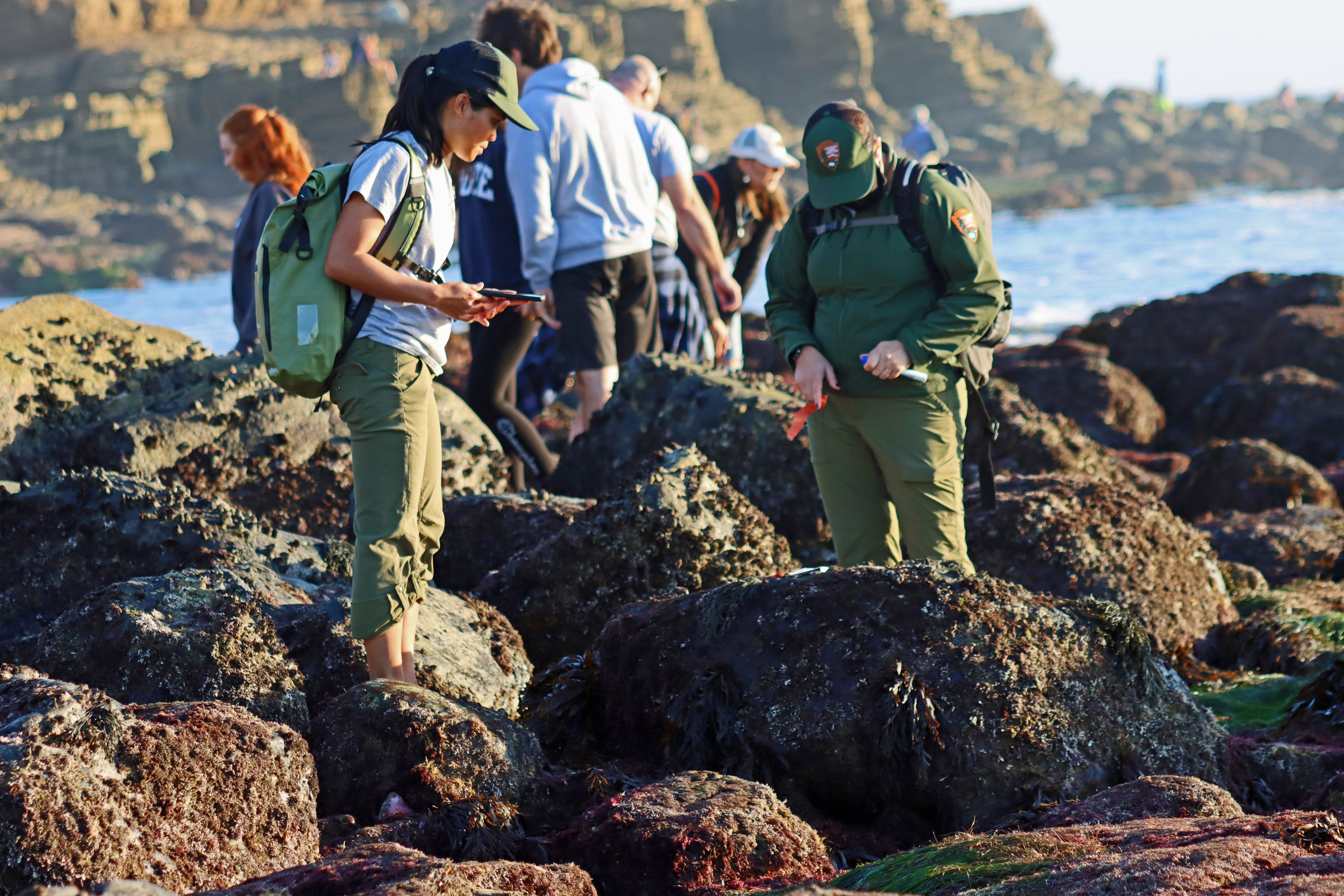 woman in uniform walking on rocky beach