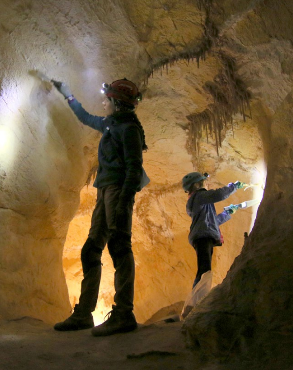 Lint in Giant's Ear Two volunteers removing lint from the walls of the place called the Giant's Ear in Lehman Caves