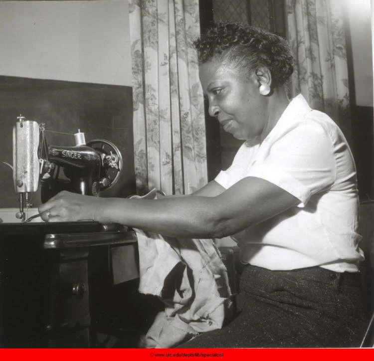 Liz Snyder, sewing class teacher, sewing. A Black woman sews with a singer sewing machine.