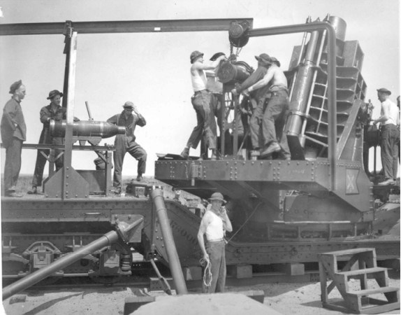 a group of young men loading a twelve inch mortar