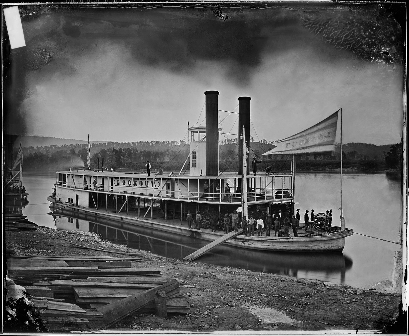 Look Out Transport Steamer on Tennessee River Civil War - Wikipedia Wooden steamboat with a deck and two chimney stacks sailing down a river. About 20 men are on the steamboat.