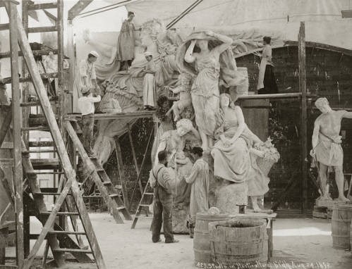black and white photo of men and women working on a large sculpture