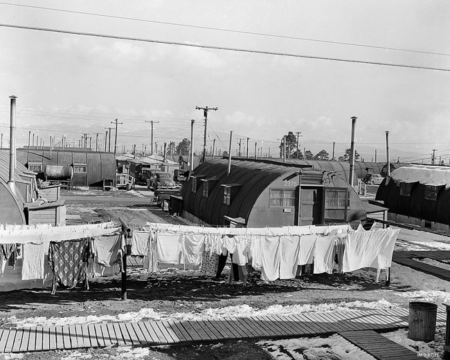 Black and white photo of housing units with laundry hanging in the foreground
