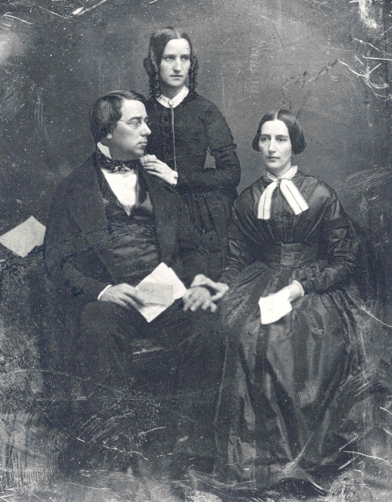 GPM, CCM, Lucy Crane black and white historic portrait photo, George Perkins Marsh sits next to first wife Caroline Crane Marsh, Lucy Crane stands behind with hand on GPM's shoulder