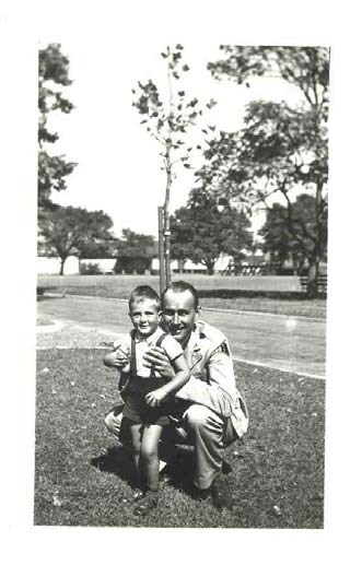 a man kneels next to his young son