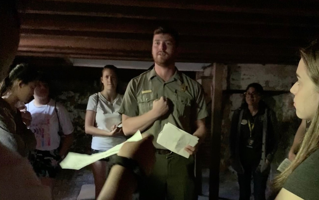 Luke Hopely in EDAL cellar A park ranger talking to a group of people in a dark cellar