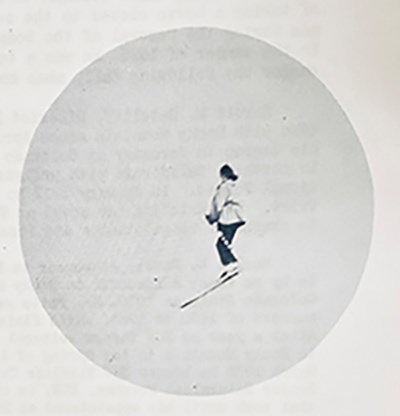A women wearing skis is seen off in the distance.
