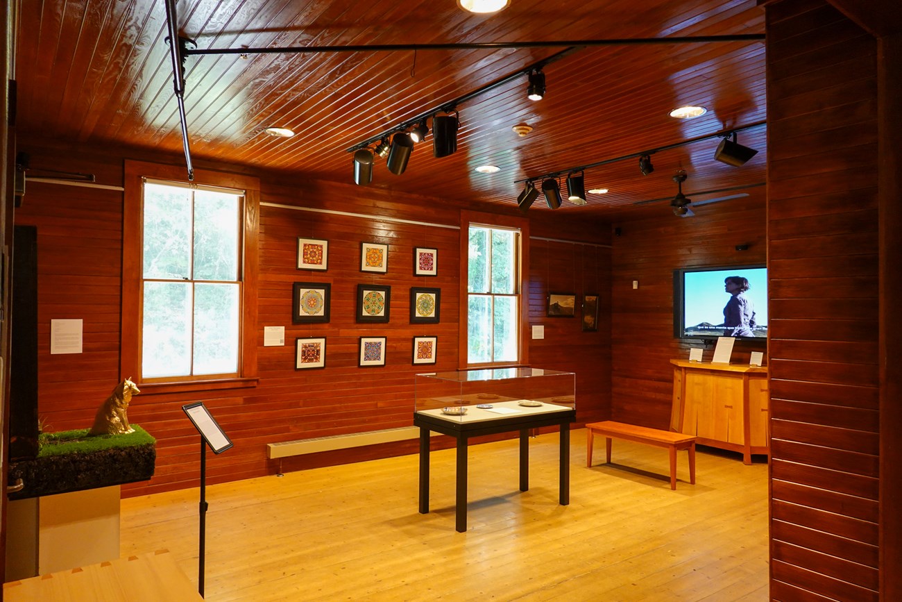 Artist-in-Residence Exhibit 2024 Multiple pieces of art with signs and cases in the Marsh-Billings-Rockefeller Visitor Center