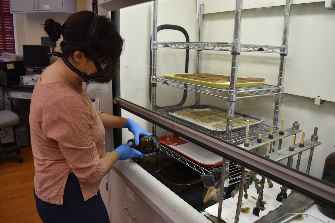 Woman in laboratory pouring oil into container