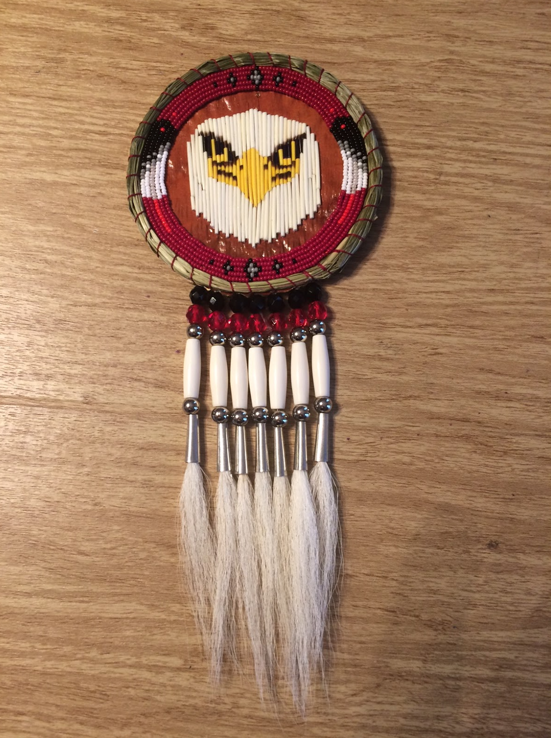 Pendant with eagle decoration and fringe made of bone and deer hair.