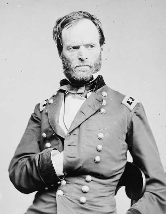 Black and white photo of a civil war soldier in uniform facing slightly right with one hand inside jacket