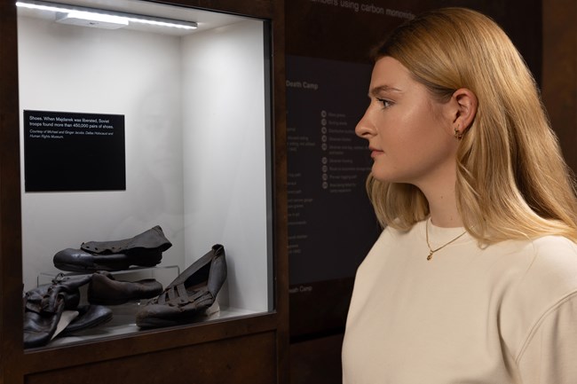 Woman looking at shoes from Majdanek Death Camp Woman looking at shoes from Majdanek