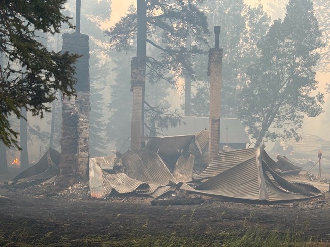 A building is crumpled to the ground with smoke surrounding it