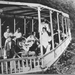 Historical image of people gathering for a dinner on a canal boat.