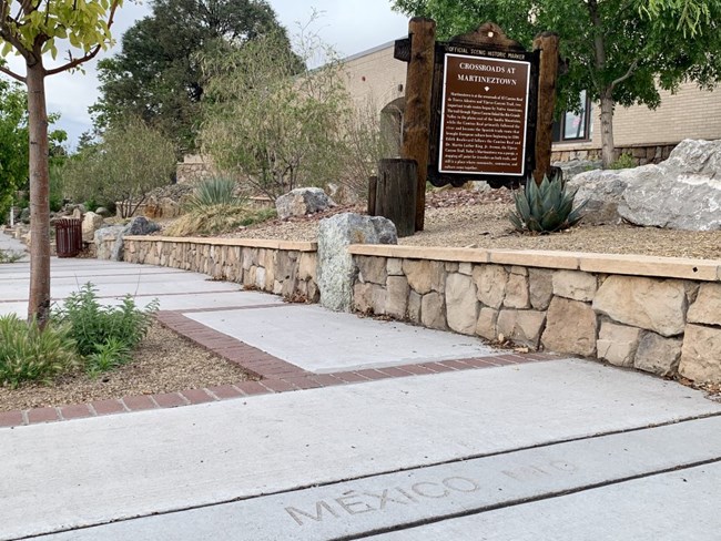 sidewalk with a marker that reads 'MEXICO'