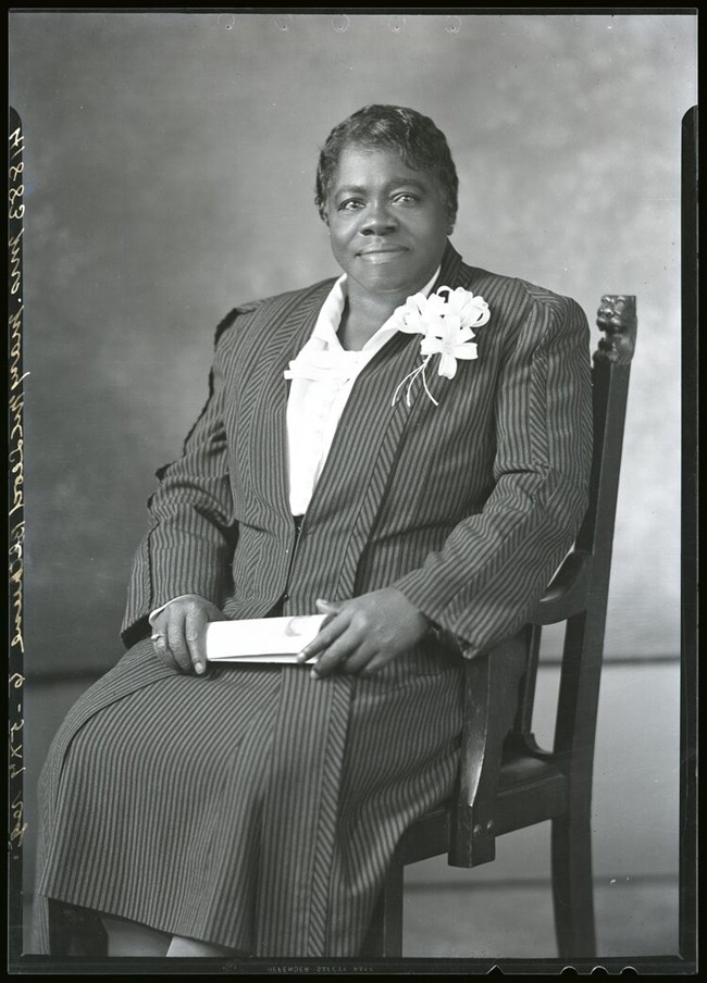 black and white seated potrait of MMBethune wearing a pinstripe suit NMAH