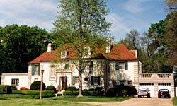 Exterior image of white stone building with red roof