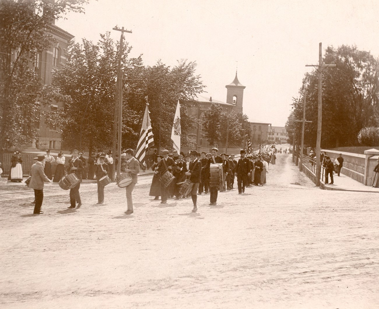 Parade walking down street with Whitin Machine Works in background