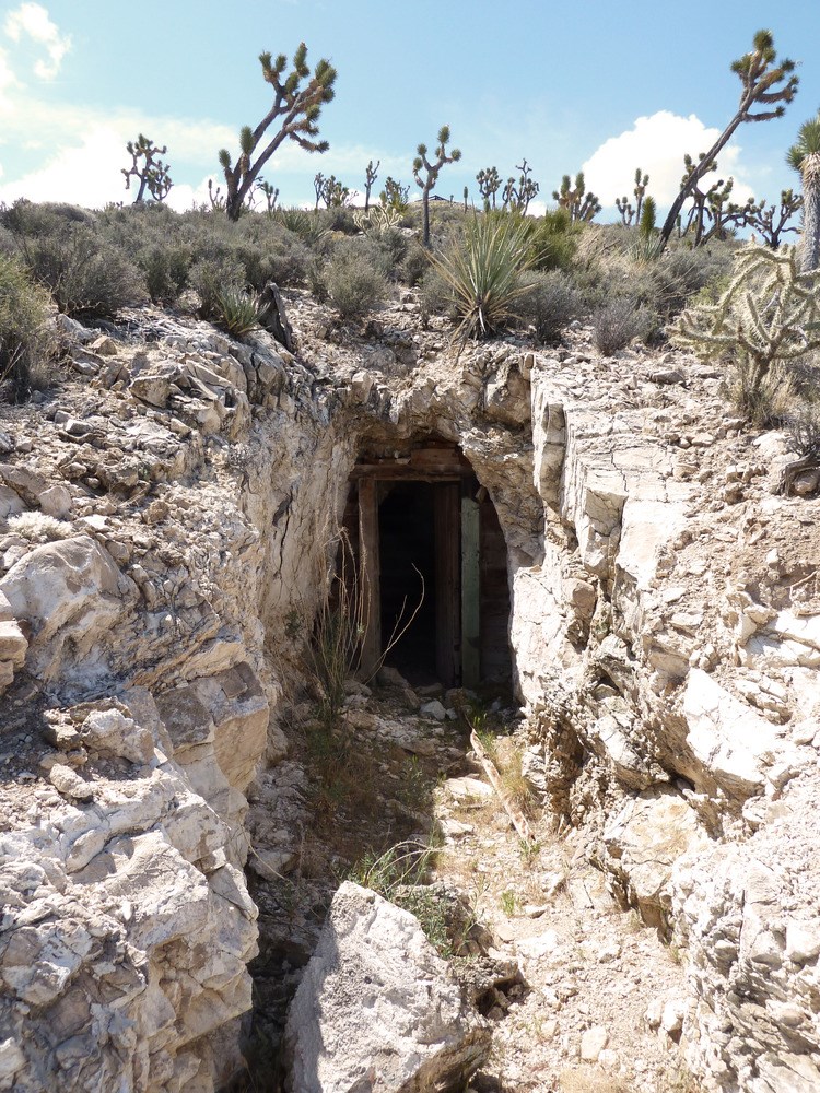 Entrance to a mine surrounded by rocky features Entrance to a mine surrounded by rocky features