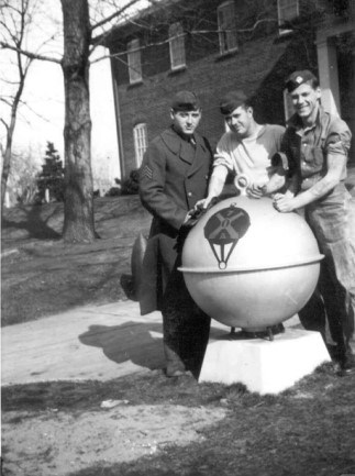 three young men in uniform stand outside barracks