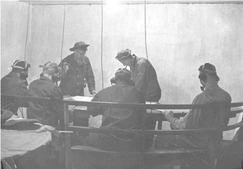 men in uniform sit around a table