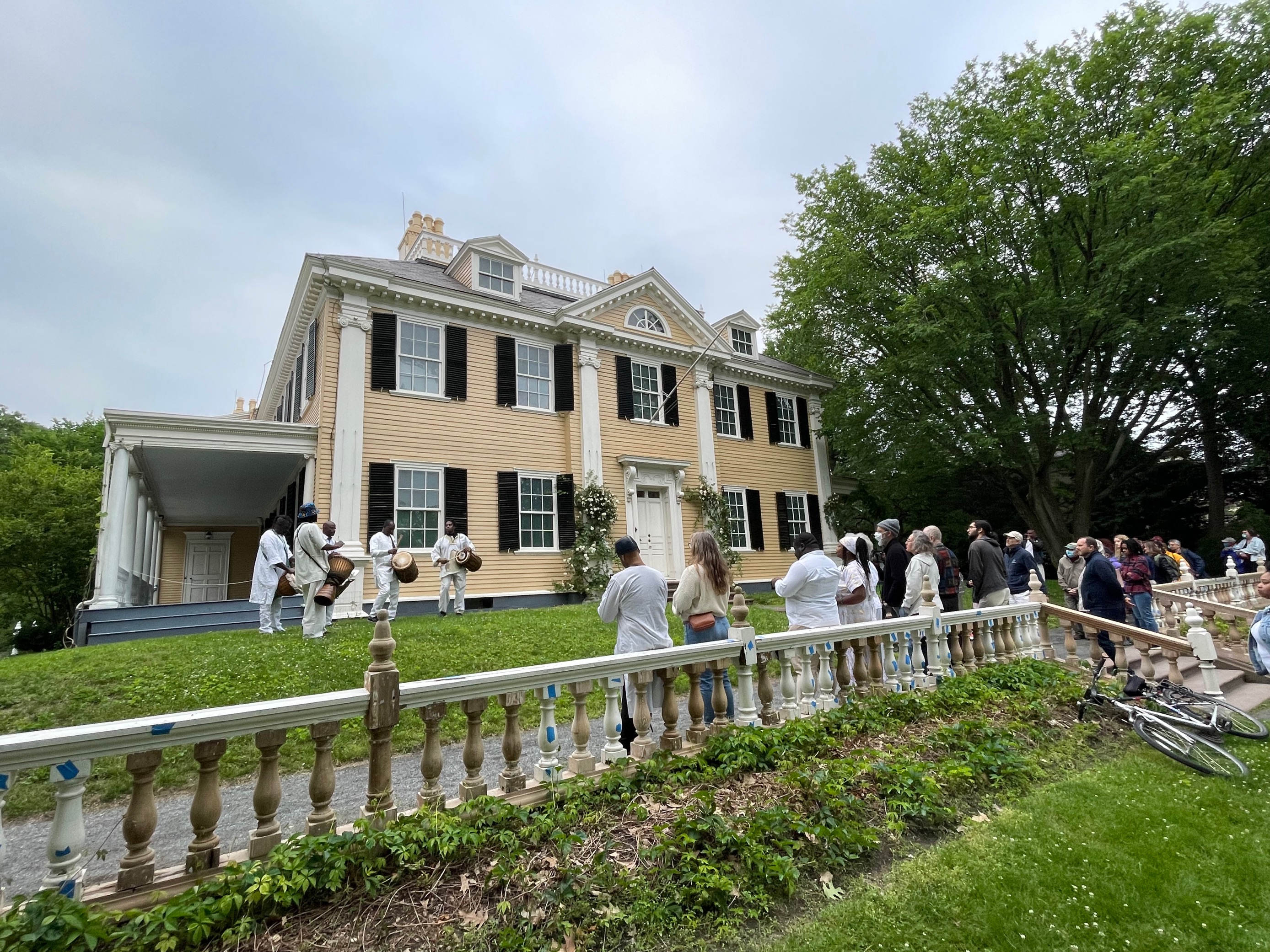 Juneteenth 2022 Drummers gathered with a crowd in front of a yellow historic house