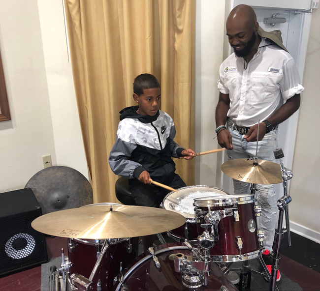 Hunter assisting children with drum lessons  during his internship in the NOLA Jazz Location