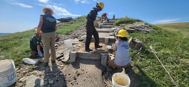 Montana Conservation Corps (MCC) team members work on repairs to tread surface and erosion control features at stairs near the summit of Buck Hill trail