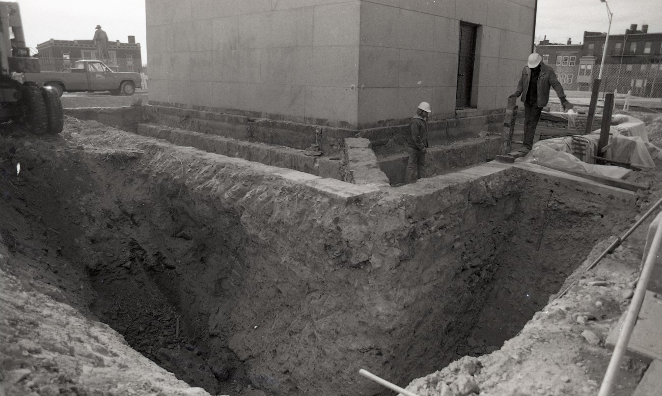 Black and white photo of a dig around the foundation of the Bunker Hill Monument.
