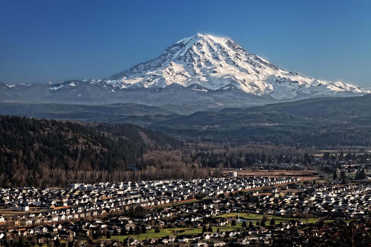 Mount Rainier from South Hill USGS photo by Ed Ruttledge Jan 18 2014 IMG_1228-ps8 snow covered volcanic peak in the distance and housing in the foreground