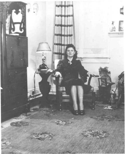 a young woman sits in a chair in her living room