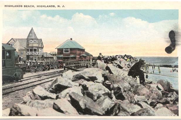 train track running between buildings and a line of boulders