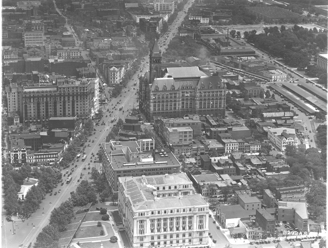 An aerial view of the federal triangle before it was constructed. Old row houses, the old Post Office building and the Center Market are all visible with Pennsylvania Ave to the left.