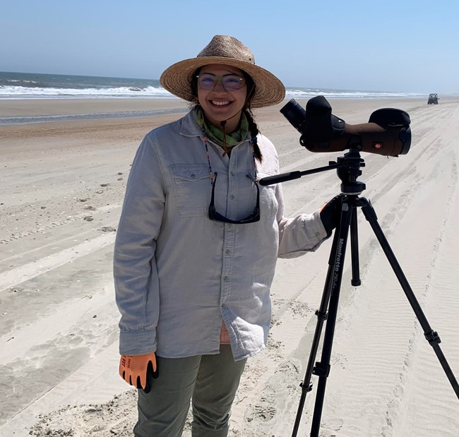 Woman standing on the beach with a camera