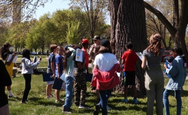 A group of school children on a field trip in a park.