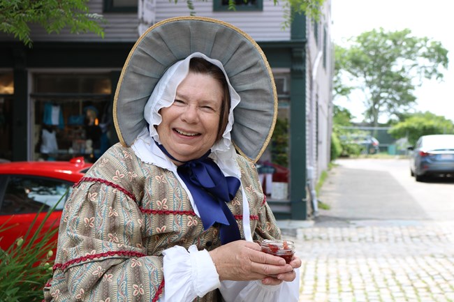 A photo of volunteer Judy Roderiques wearing historic clothing at New Bedford Whaling National Historical Park.