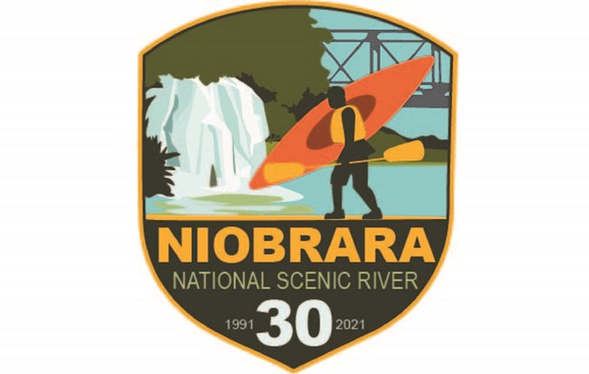 Logo with text "Niobrara National Scenic River, 30, 1991-2021" Image features an artists rendition of a person caring a kayak with a waterfall, river, and trestle bridge in the background