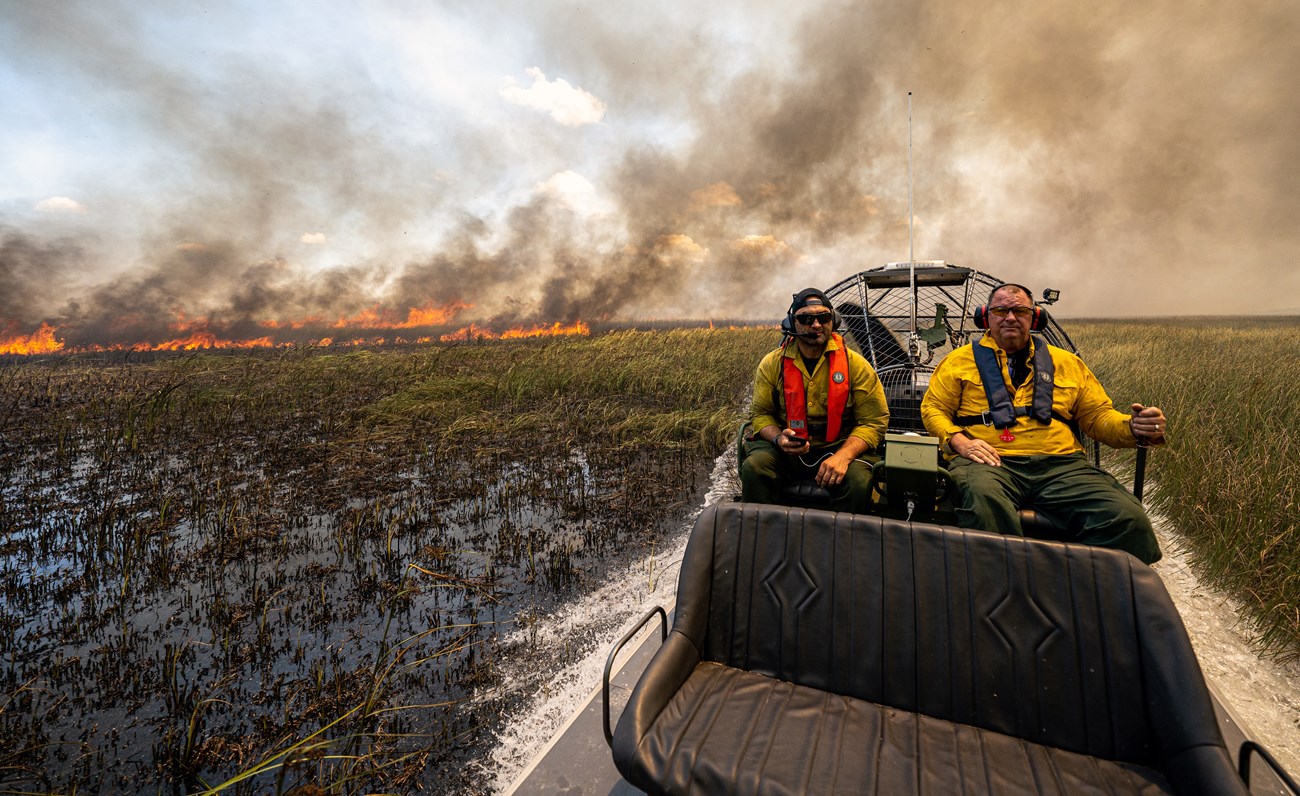 Northeast Prescribed Fire Wildland firefighters ride in an airboat through marsh.