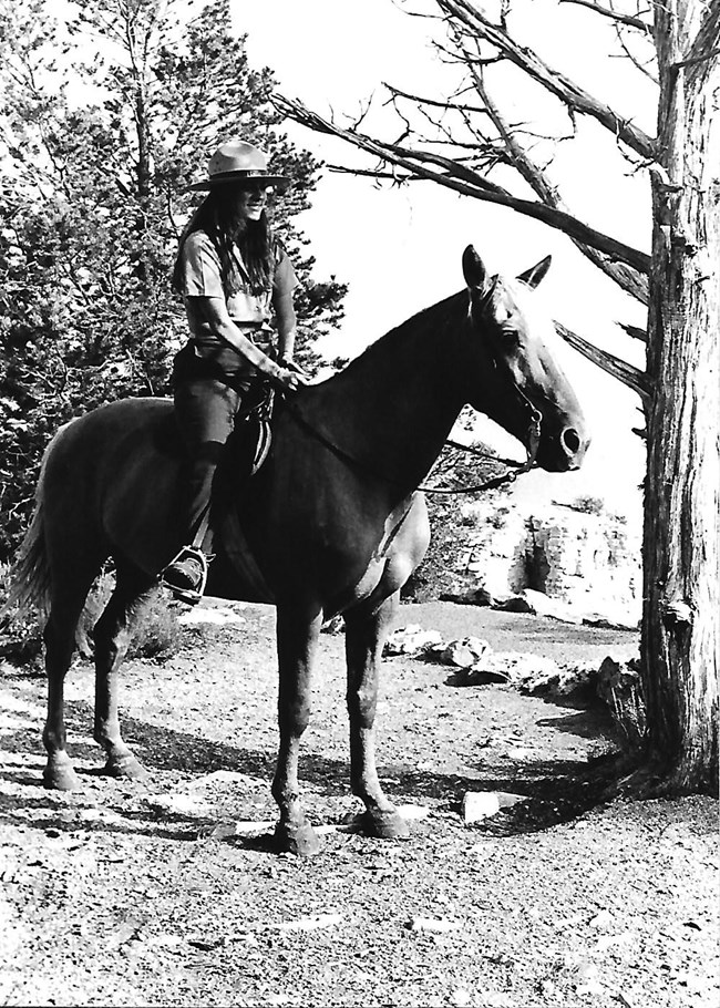 Eileen Szychowski on horseback Eileen Szychowski on horseback wearing her NPS uniform and ranger hat.