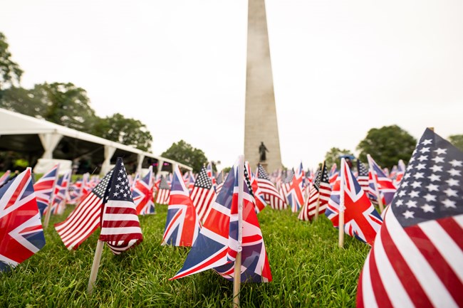 NPSFlagDay2025 lines of US and UK flags in front of the Bunker Hill Monument