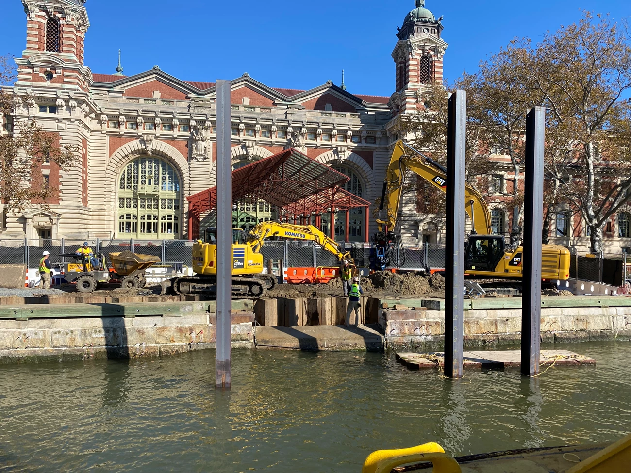 Heavy machinery work in front of a building. Heavy machinery dig into the ground in front of a large building.
