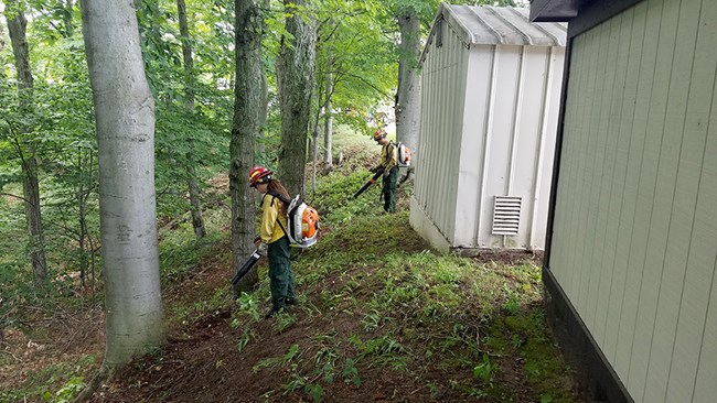 FY'21-Sleeping Bear Dunes leafblowers Firefighters use leaf blowers to remove dead leaves from around two structures.