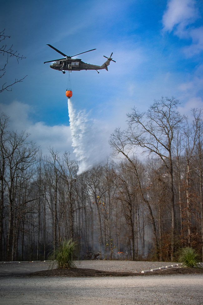 Water drop A helicopter drops water from a bucket suspended below it